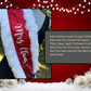 Add a festive touch to your holiday look with this vibrant red sequin “Mrs. Claus” sash! Trimmed in soft, white faux fur for a cozy, wintery feel, this sash catches the light with every step. A chic black satin bow with a gold accent adds a pop of elegance, completing the classic Christmas-inspired design.