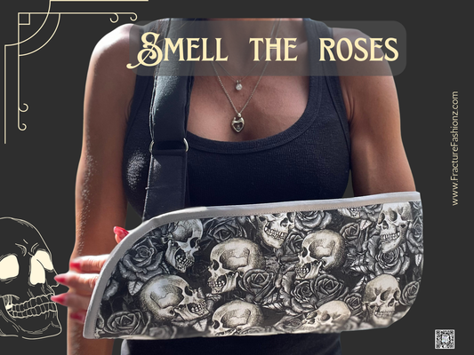 Person wearing a padded arm sling with skull and rose pattern, text 'Smell The Roses' displayed.