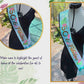 Ceinture en satin noir avec sequins et inscription dorée, bordée d'un galon doré